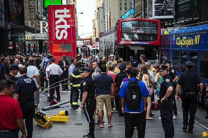 Emergency personnel gather to assess injuries and damage following a collision between two tour buses in the Times Square region of New York August 5, 2014. -- PHOTO: REUTERS