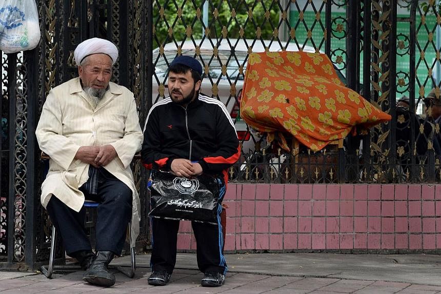 Muslim men outside a mosque in Urumqi, the capital of Xinjiang, on May 23, 2014. A city in China's restive western region of Xinjiang has banned people with head scarves, veils and long beards from boarding buses, as the government battles unrest wit