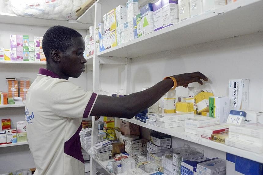 A pharmacist searches for drugs in a pharmacy in Lagos, Nigeria, on July 26, 2014. An experimental drug given to two American patients with Ebola is made from tobacco leaves and is hard to produce on a large scale, a leading US doctor said on Tuesday