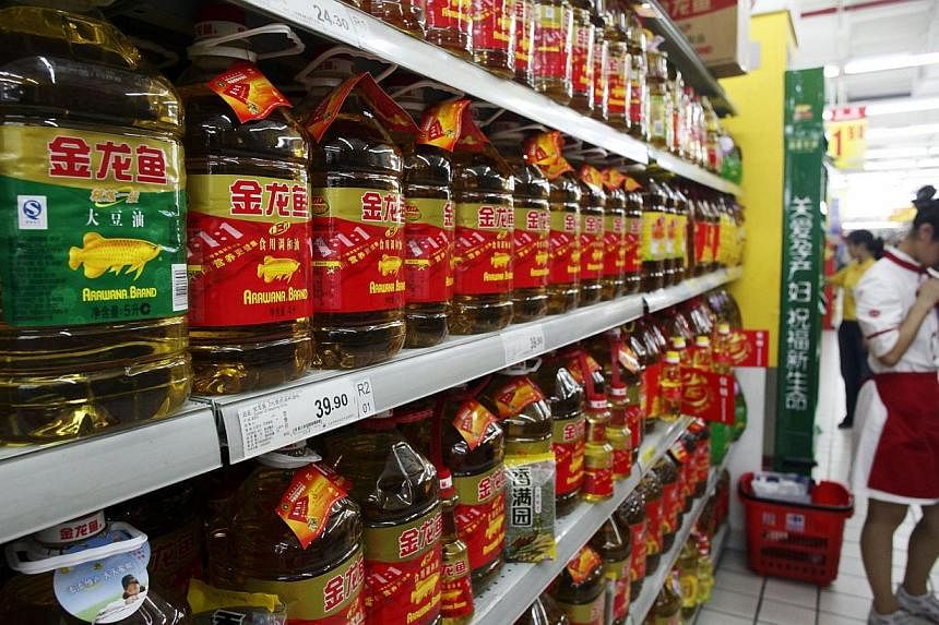Bottles of Wilmar International Ltd. Arawana brand cooking oil sit on a shelf at a supermarket in Shanghai, China, on Friday, Aug 14, 2009.&nbsp;Commodities player Wilmar International has reported a 22 per cent drop in its second quarter net profit 