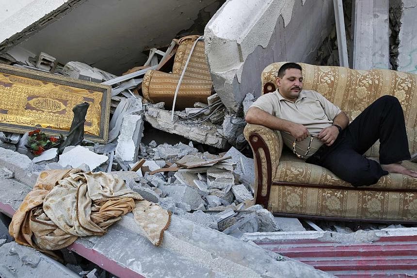 A Palestinian sits amid the ruins of destroyed homes in the Shejaia neighbourhood, which witnesses said was heavily hit by Israeli shelling and air strikes during an Israeli offensive, in Gaza City on Aug 6, 2014. -- PHOTO: REUTERS