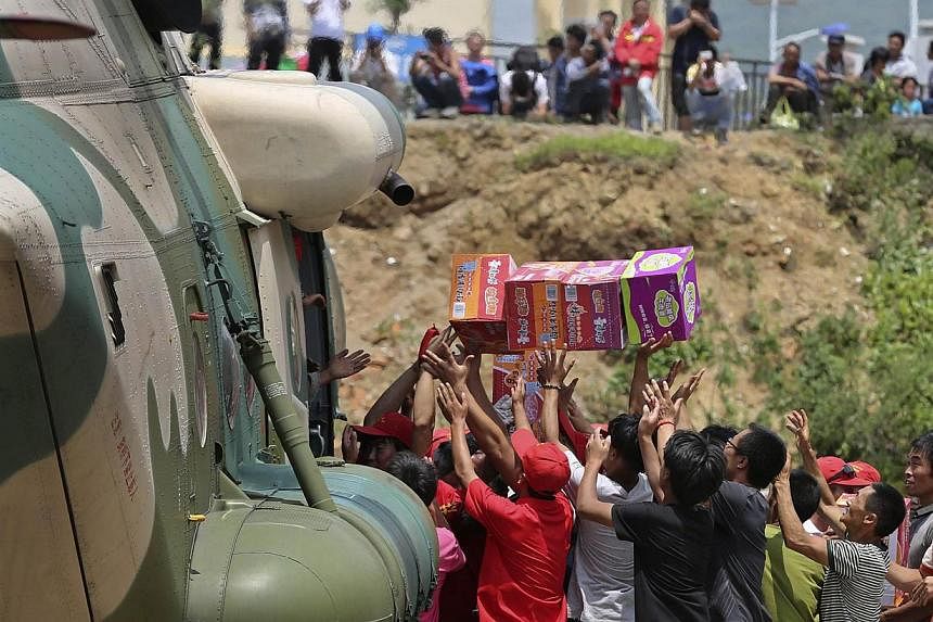 People rush for relief food supplies at an earthquake zone in Ludian, Zhaotong, Yunnan province on Aug 6, 2014. The Singapore Red Cross is sending US$50,000 (S$62,400) in humanitarian aid to help survivors of Sunday's earthquake in Yunnan, China, the