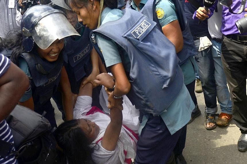 Bangladeshi police detain Garments Sramik Oikya Forum president Moshrefa Mishu (centre) during clashes with protesting garments workers in Dhaka on Thursday, Aug 7, 2014.&nbsp;Bangladesh police on Thursday fired tear gas and stormed a garment factory