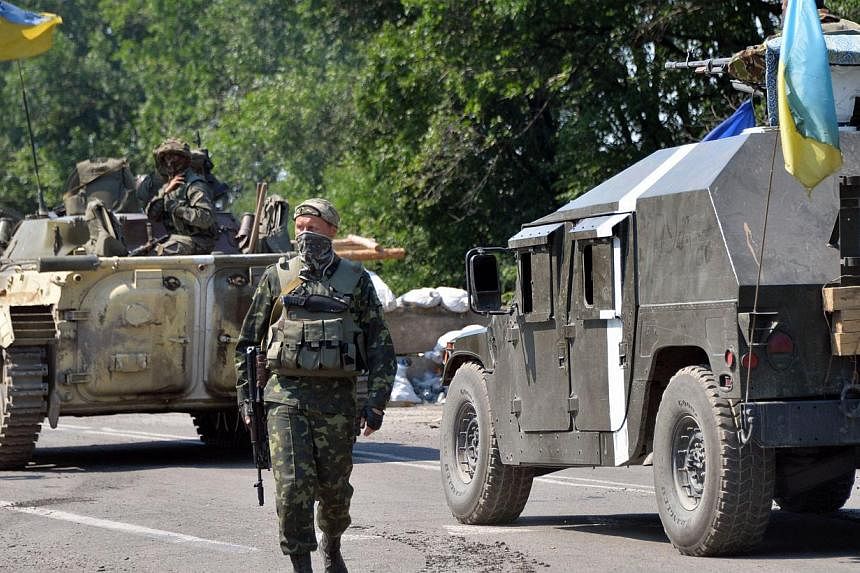 Ukrainian troops guard a checkpoint near the eastern Ukrainian city of Debaltseve in the Lugansk region on Aug 1, 2014. Ukraine scrapped a ceasefire around the crash site of downed Malaysian Airlines flight MH17 a day after international experts anno