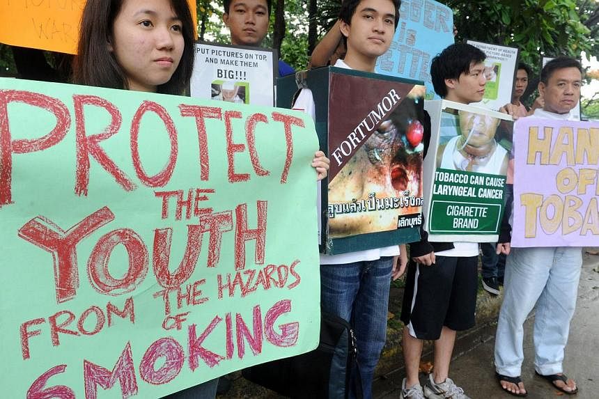 Various civic organization hold a "fun walk" with activist Roman Catholic priest Father Robert Reyes campaigning for a law for graphic health warnings on tobacco products in Manila on June 10, 2014.&nbsp;Graphic warnings on Philippine cigarette packe
