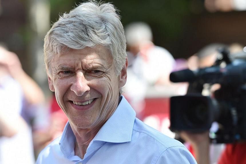 Arsenal's French manager Arsene Wenger smiles durin g their victory parade in London on May 18, 2014, following their win in the English FA Cup final football match on May 17, 2014 against Hull City. -- PHOTO: AFP
