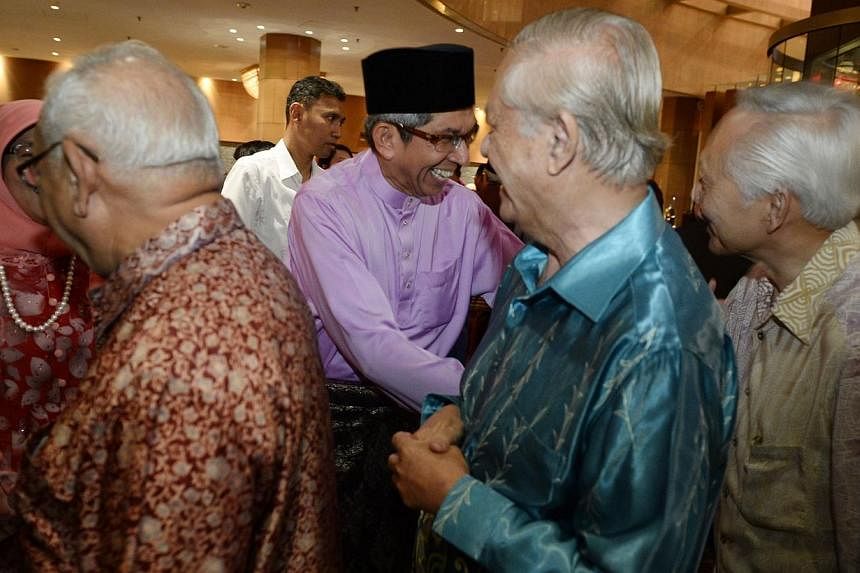 Minister-in-charge of Muslim Affairs Yaacob Ibrahim (centre) greets (from left) former minister of state Othman Haron Eusofe, 73, and former MPs Haji Wan Hussin Zoohri, 76, and Rohan Kamis, 65, at an annual Hari Raya gathering on Aug 8, 2014. -- ST P