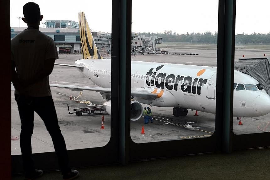 A Tigerair plane at Changi Airport on July 3, 2013.&nbsp;Budget carriers Tigerair and Scoot have received approval from Singapore's competition watchdog to work closely to plan flights, schedules and fares. -- PHOTO: ST FILE&nbsp;