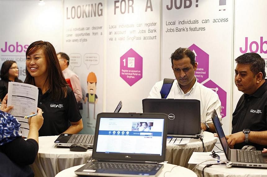 WDA career coaches help job applicants sift through the Jobs Bank website on 14 July, 2014. The portal now has more than 50,000 jobs for Singaporeans up for grabs. -- ST PHOTO: DESMOND LUI