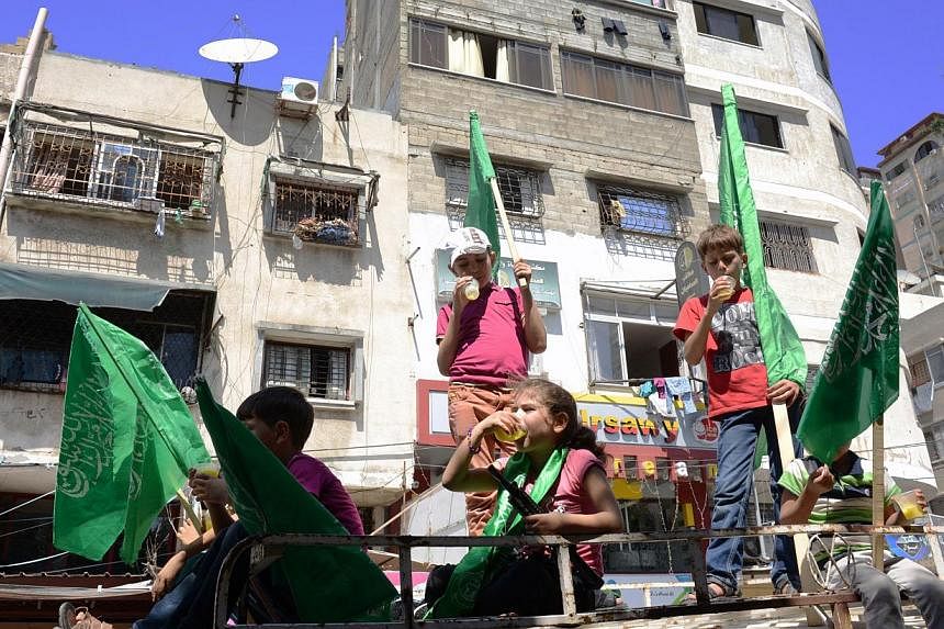 Palestinian children enjoy refreshments and hold Hamas flags during rally in support of the movement in downtown Gaza City on August 7, 2014 while diplomatic efforts entered a final countdown in Cairo, as Egyptian mediators rushed to broker an extens
