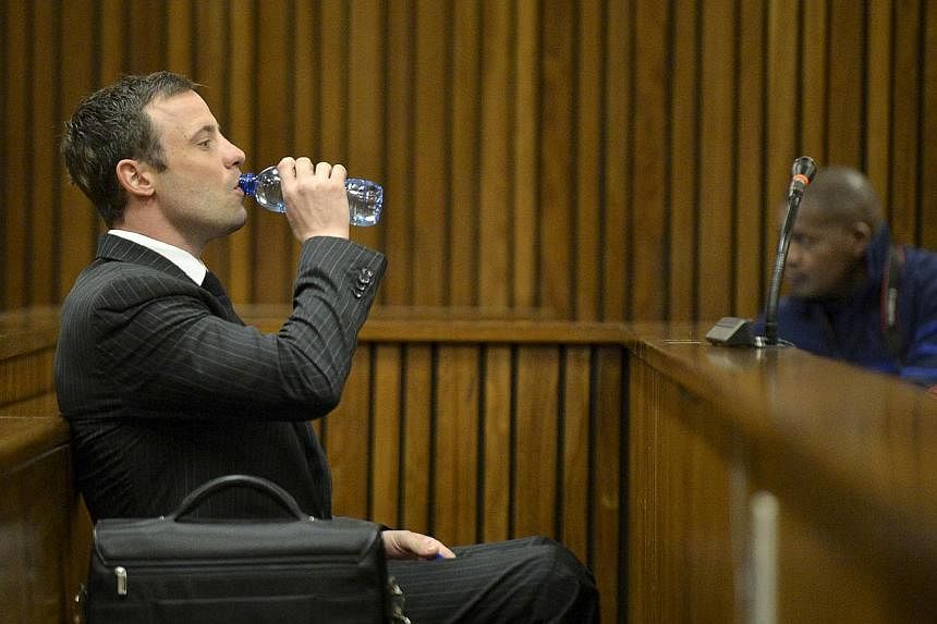 South African Olympic and Paralympic sprinter Oscar Pistorius drinks from a bottle as he sits in the dock before the defence's final argument in the North Gauteng High Court in Pretoria on Aug 8, 2014.&nbsp;Pistorius' "primal instincts" kicked in whe