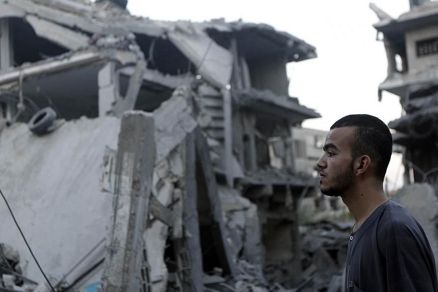 A Palestinian man stands looking at destroyed buildings in the Jabalia refugee camp in the northern Gaza Strip on Aug 8, 2014. Israeli warplanes on Friday pounded targets across Gaza, killing at least five Palestinians, and militants fired dozens of 
