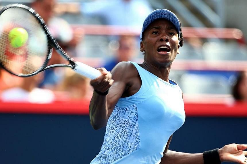 Venus Williams of the USA returns a shot to Carla Suarez Navarro of Spain in their quarterfinal match during the Rogers Cup at Uniprix Stadium on August 8, 2014 in Montreal, Canada. -- PHOTO: AFP