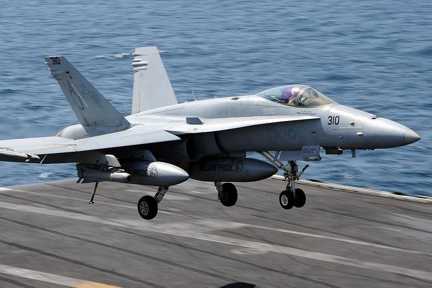 An F/A-18C Hornet assigned to the Valions of Strike Fighter Squadron (VFA) 15 as it prepares to land on the flight deck of the aircraft carrier USS George H.W. Bush (CVN 77) on July 29, 2014, in the Gulf.&nbsp;International airlines steered clear of 