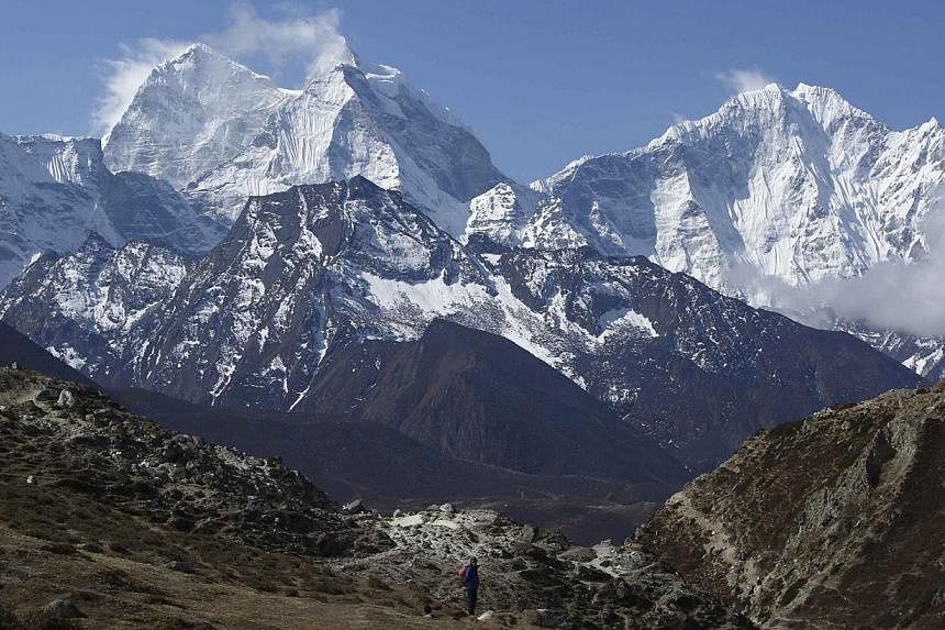 A trekker walks in front of Mount Thamserku while on his way back from Everest base camp near Pheriche in Solukhumbu District on May 3, 2014.&nbsp;Foreign mountaineers will have to spend more for the insurance cover of their Sherpa guides to climb an