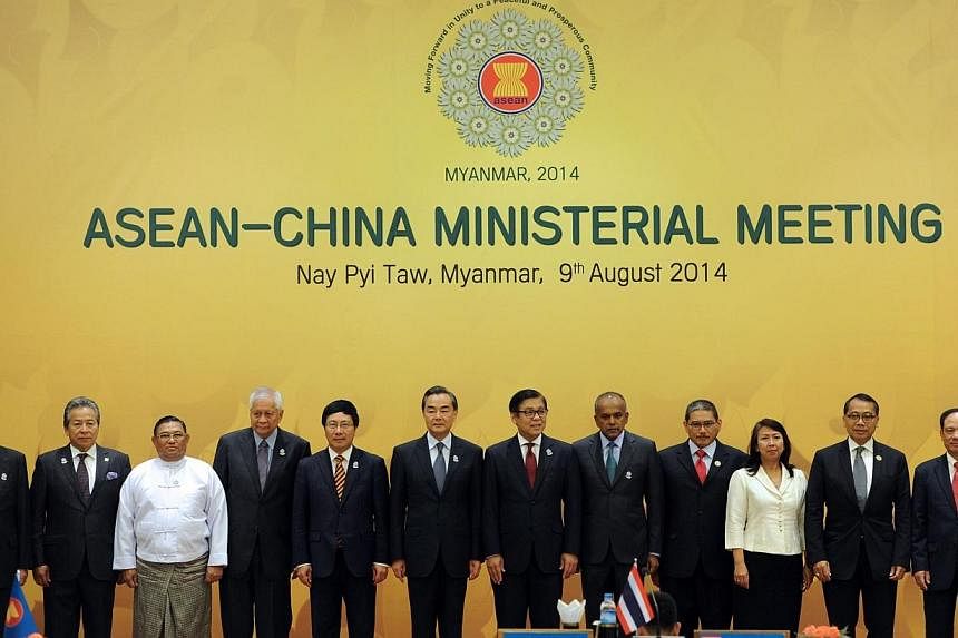 Chinese Foreign Minister Wang Yi (sixth from L) and ASEAN foreign ministers and officials pose for a photo prior to the ASEAN-China ministerial meeting at the Myanmar International Convention Center (MICC) in Naypyidaw on August 9, 2014. -- PHOTO: AF