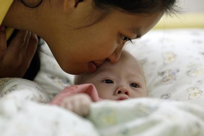 Gammy, a baby born with Down's Syndrome, is kissed by his surrogate mother Pattaramon Janbua at a hospital in Chonburi province August 3, 2014.&nbsp;An Australian couple at the centre of a Thai surrogate scandal on Sunday denied they deliberately aba