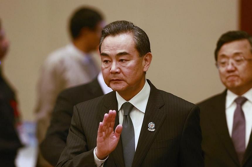 Chinese Foreign Minister Wang Yi waves as he arrives to attend an ASEAN-CHINA ministerial meeting at the Myanmar International Convention Centre (MICC) in Naypyitaw, August 9, 2014. -- PHOTO: REUTERS