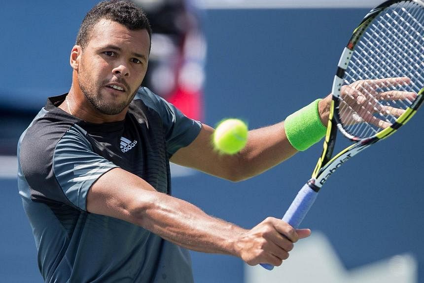Jo-Wilfried Tsonga of France returns the ball to Grigor Dimitrov of Bulgaria during his 6-4, 6-3 win in their semi-final match at the Rogers Cup at the Rexall Centre in Toronto, Ontario, on Aug 9, 2014. -- PHOTO: AFP