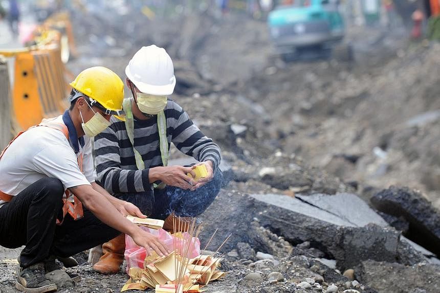 Rescue workers burn ghost money to the victims of the gas explosion in the southern Kaohsiung city on Aug 2, 2014.&nbsp;Taiwan's Cabinet on Sunday said it has accepted the resignation of the economics minister who stepped down to try to ease politica