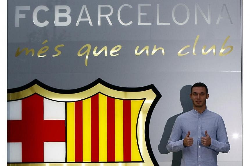 Belgium soccer player Thomas Vermaelen poses next to a logo at his arrival at FC Barcelona's offices in Barcelona, on Aug 9, 2014. -- PHOTO: REUTERS&nbsp;