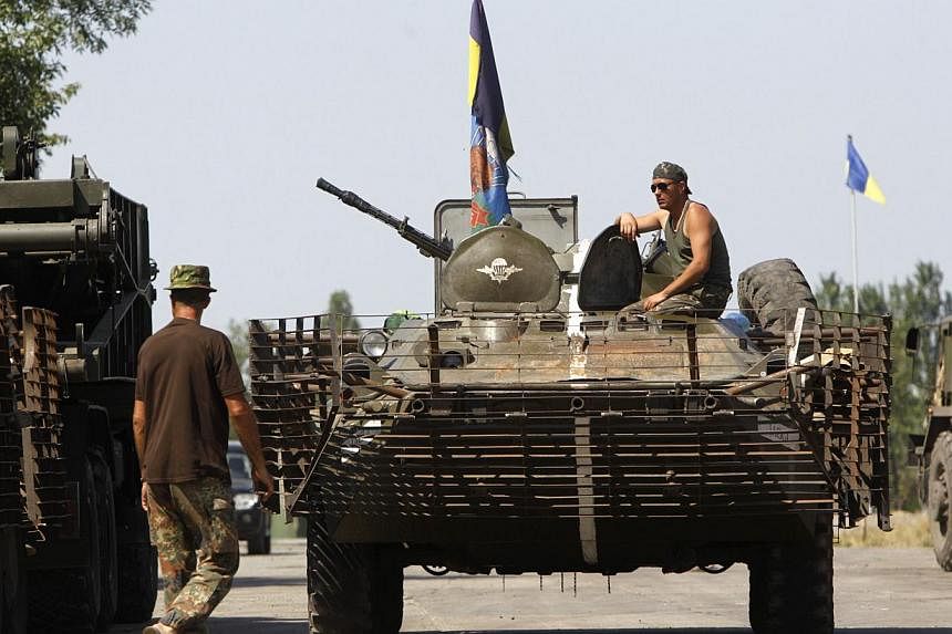 A Ukrainian serviceman sits on a military armoured vehicle near Donetsk on Aug 9, 2014. Ukraine said on Saturday it had headed off an attempt by Russia to send troops into Ukraine under the guise of peacekeepers with the aim of provoking a large-scal