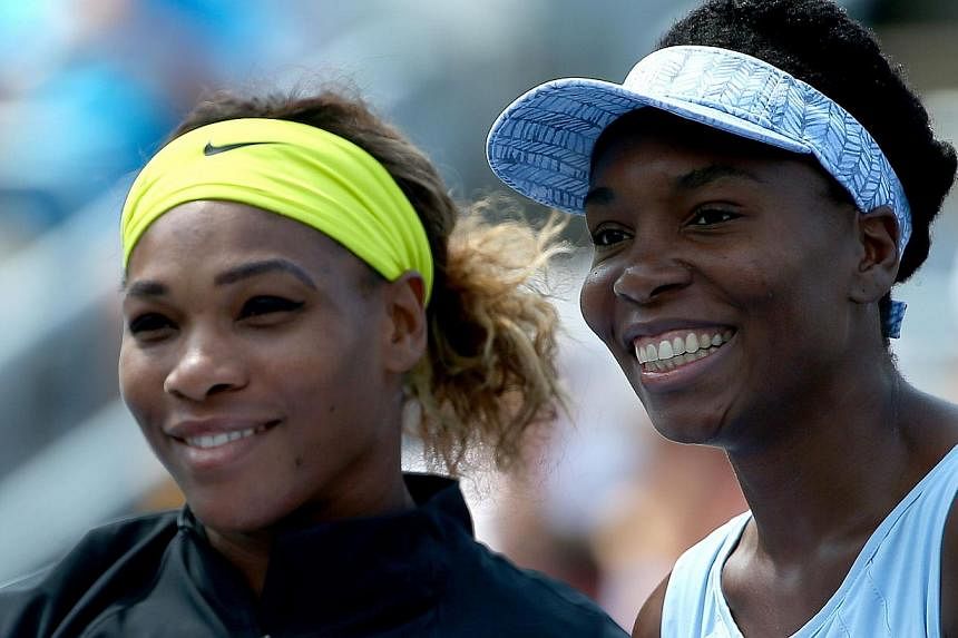 Serena Williams of the USA and Venus Williams (right) of the USA pose before their women's semifinals match in the Rogers Cup at Uniprix Stadiumin Montreal, Canada on Aug 9, 2014 . -- PHOTO: AFP