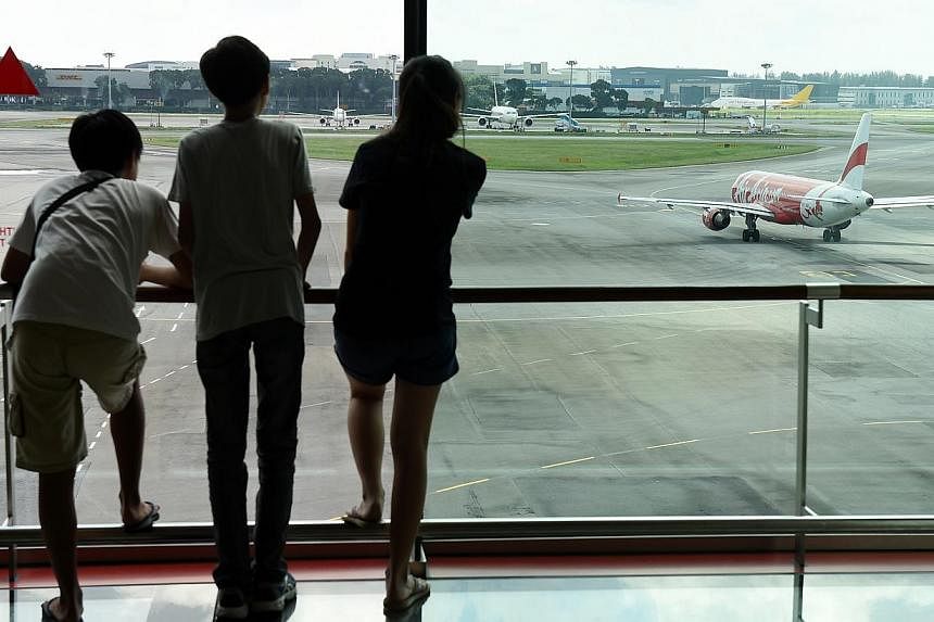 Members of the public looking at an aircraft taxiing out from the aircraft parking stands at Changi Airport. -- PHOTO: ST FILE