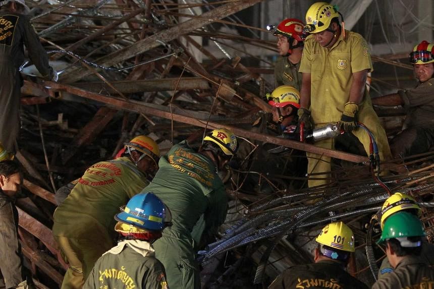 Rescue workers search through the rubble of a collapsed condominium building, which had been under construction, in Pathum Thani province, on the outskirts of Bangkok, August 11, 2014. The six-storey condominium building in Thanyaburi district collap