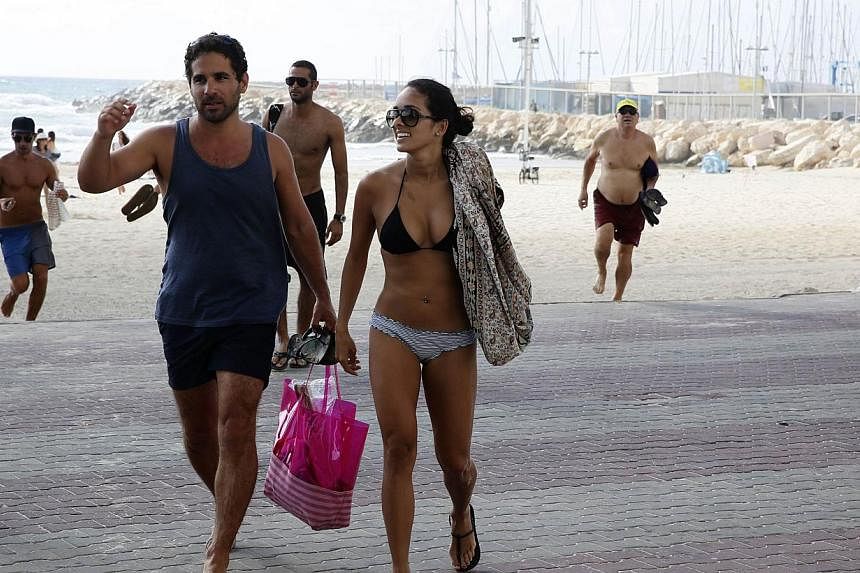 Israelis and tourists running from the beach to take cover in a nearby hotel in the costal city of Tel Aviv on July 14, 2014 during a rocket attack fired by Palestinian militants from the Gaza Strip. In July, 218,000 visitors were recorded entering I