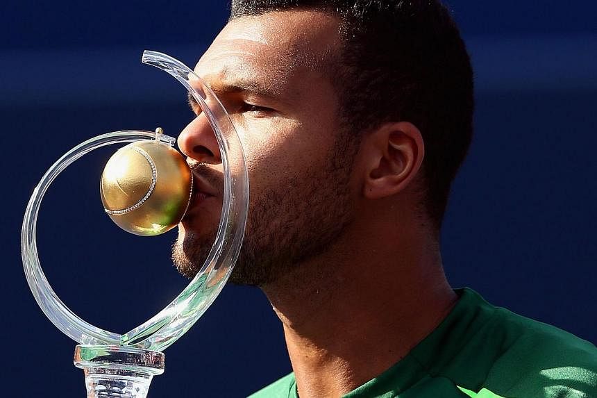 Jo-Wilfried Tsonga of France kisses the Rogers Cup trophy after his win against Roger Federer of Switzerland during the Rogers Cup at Rexall Centre at York University on August 10, 2014 in Toronto, Canada. -- PHOTO: AFP&nbsp;
