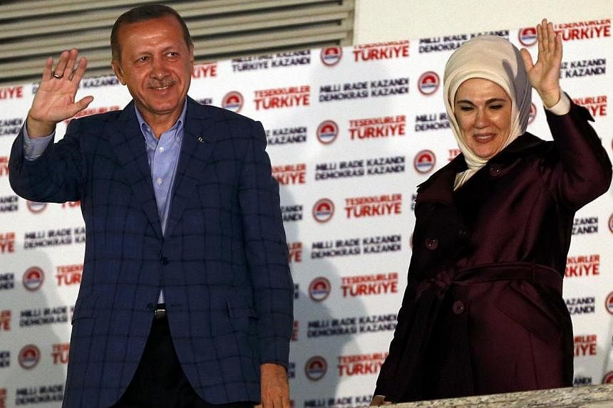 Turkey's Prime Minister Tayyip Erdogan and wife Ermine wave to supporters as he celebrates his election victory in front of the party headquarters in Ankara on August 10, 2014. Mr Erdogan secured his place in history as Turkey's first directly electe