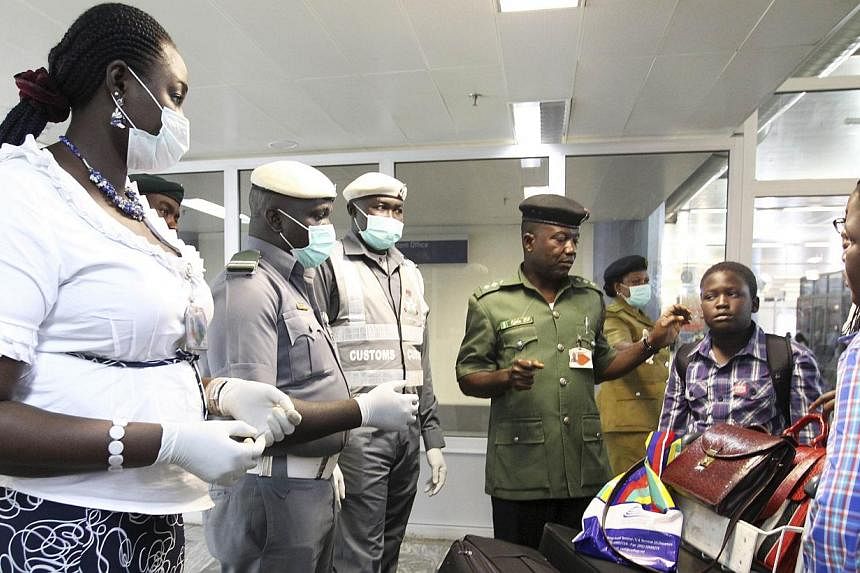 Nigerian custom officers wearing face masks and gloves screen passengers arriving at Nnamdi Azikiwe International Airport in Abuja August 11, 2014.-- PHOTO: REUTERS