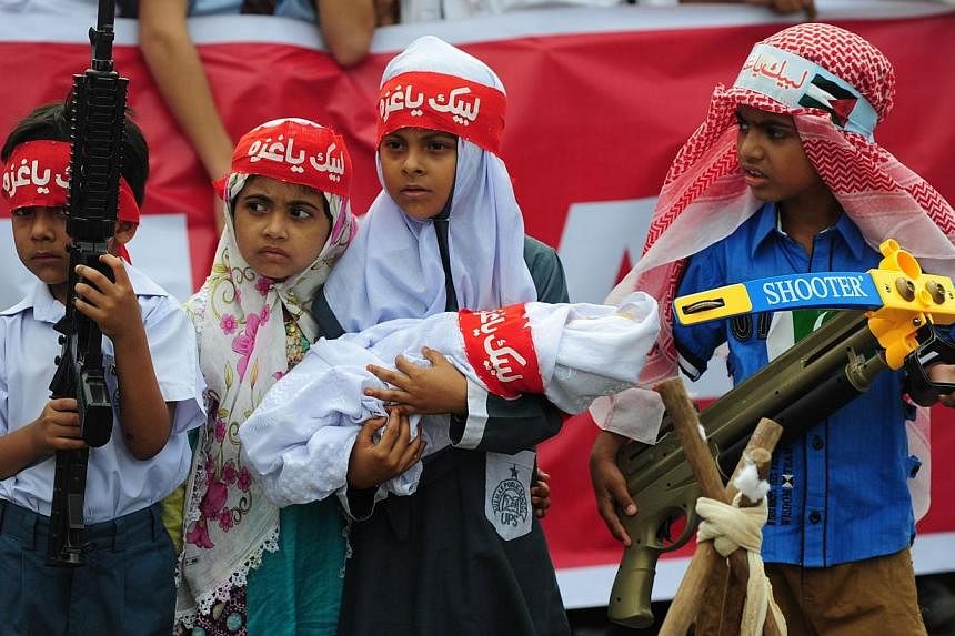 Pakistani children hold toy weapons during a demonstration organised by the fundamentalist Islamic political party Jamaat-i-Islami (JI) in Karachi on Aug 12, 2014, against Israeli military action in Gaza.&nbsp;-- PHOTO: AFP