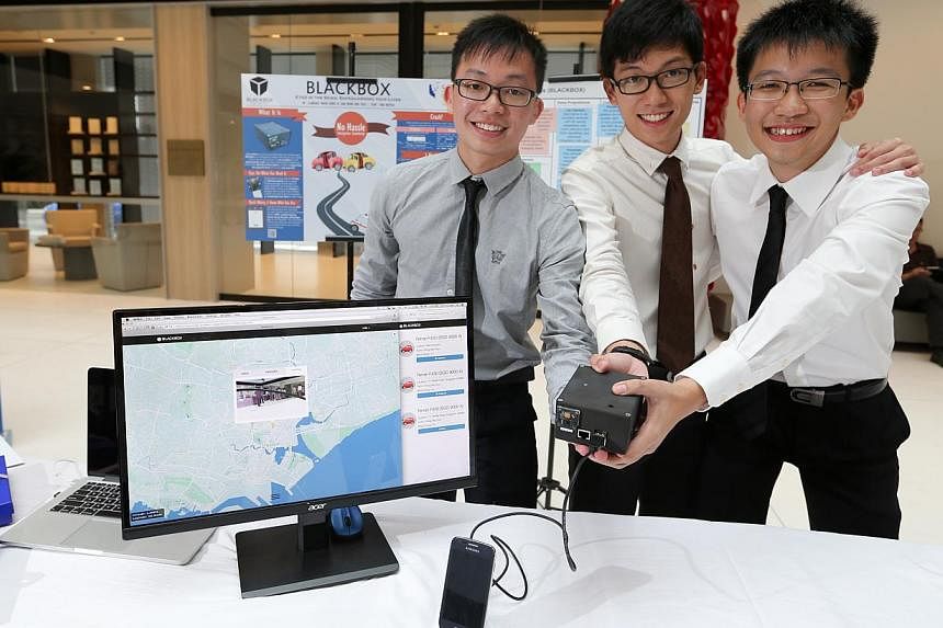 SMU undergraduate Clarence Ngoh (centre) and full-time national servicemen Kong Yu Jian (left) and Wong Wai Tuck with their invention, the BlackBox, a car crash detection system that alerts emergency responders. -- ST PHOTO: ONG WEE JIN