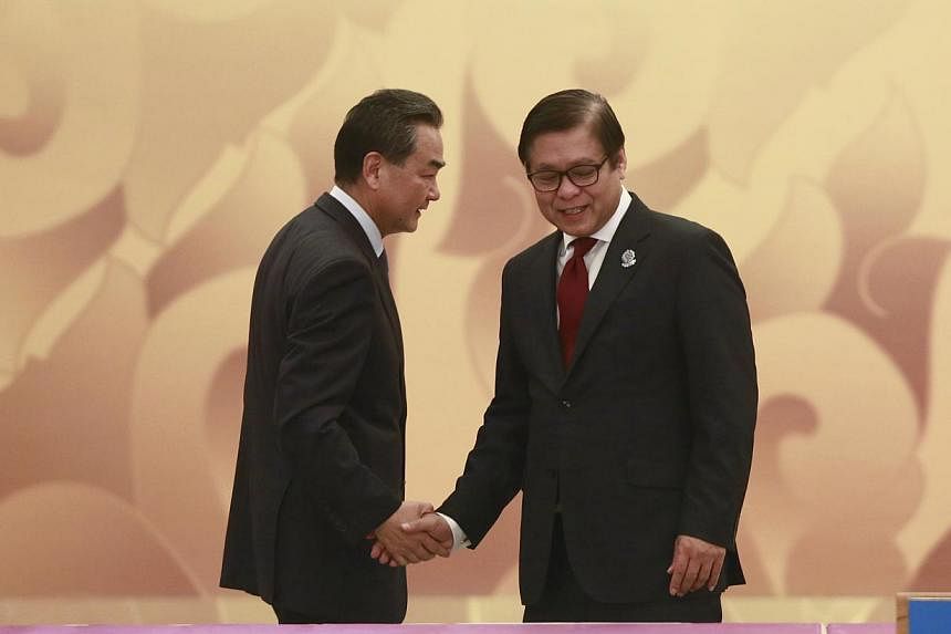 China's Foreign Minister Wang Yi and Thailand's Foreign Ministry Permanent Secretary Sihasak Phuangketkeow (R) shake hand as they attend the Asean-China ministerial meeting at Myanmar International Convention Centre (MICC) in Naypyitaw on August 9, 2