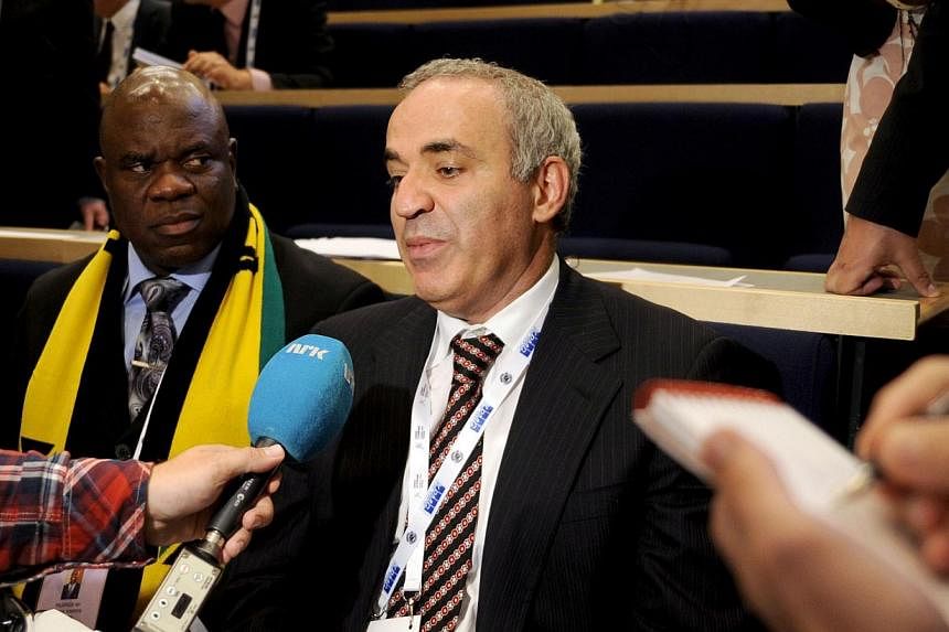 Russian former chess champion Garry Kasparov (right) answers journalists' questions after he lost the presidential election of the International Chess Federation in Tromso, Norway, on August, 11, 2014 in a highly politicised vote. He is seated next t