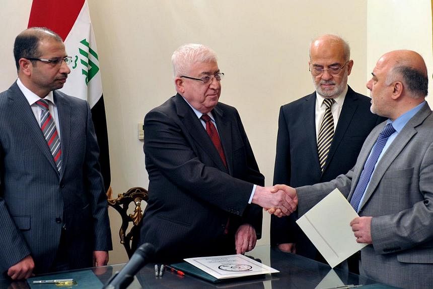 A hand out photograph made available by the offices of Iraqi President on August 11, 2014, shows newly elected Iraqi parliament speaker Salim al-Juburi (left) watching as Iraqi President Fuad Masum (second from left) shakes hands with deputy parliame
