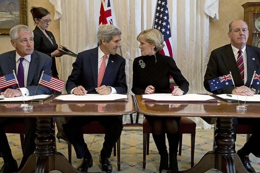 Australian Foreign Minister Julie Bishop (second right) speaks with US Secretary of State John Kerry alongside US Secretary of Defense Chuck Hagel (left) and Australian Defence Minister David Johnston (right) during a signing ceremony for a joint for