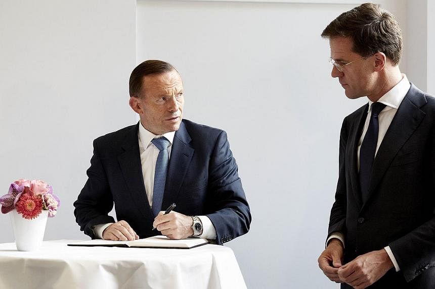 Australian Prime Minister Tony Abbott (left) accompanied by Dutch counterpart Mark Rutte signs a condolence register during his visit to Mr Rutte's official residence Catshuis in The Hague, The Netherlands, on August 11, 2014. Mr Abbott is visiting t
