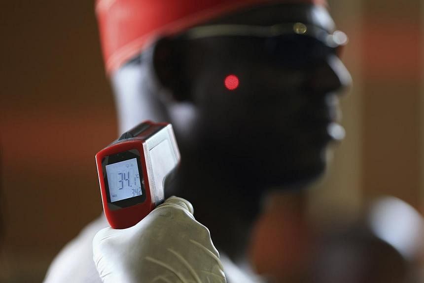 A man has his temperature taken using an infrared digital laser thermometer at the Nnamdi Azikiwe International Airport in Abuja on Aug 11, 2014.&nbsp;-- PHOTO: REUTERS