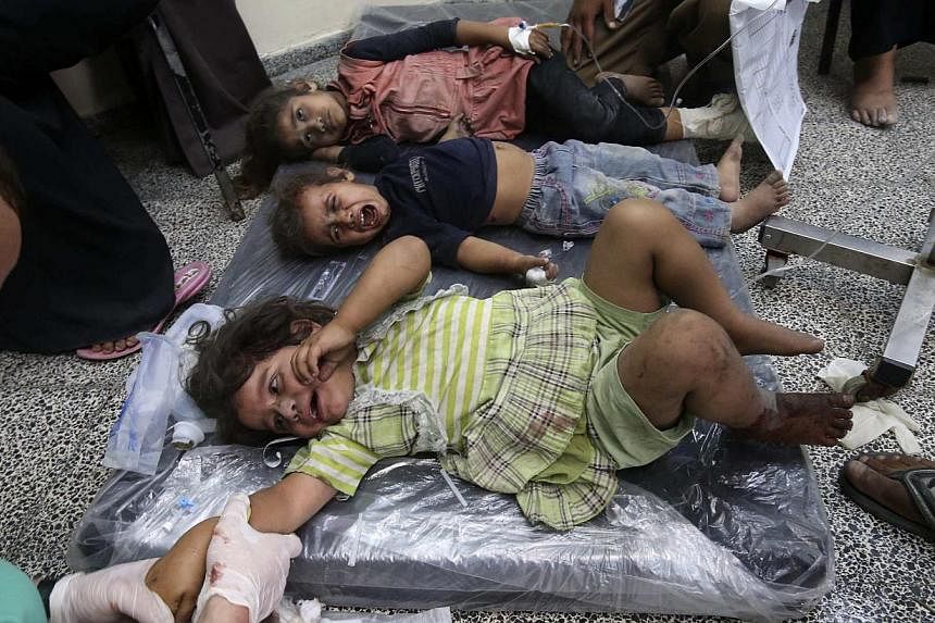 Palestinian children, whom medics said were wounded by Israeli shelling, receive treatment at a hospital in Rafah in the southern Gaza Strip on Aug 1, 2014. -- PHOTO: REUTERS&nbsp;