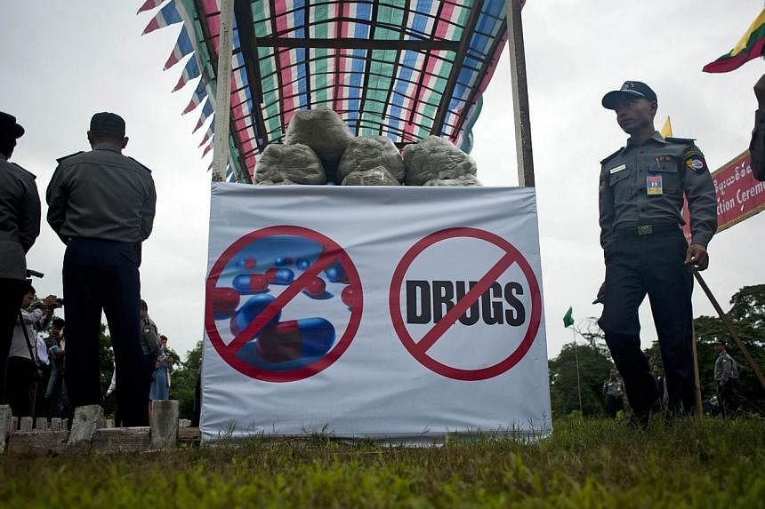 Myanmar police stand beside seized drugs before they are destroyed during a ceremony to mark the UN's International Day against Drug Abuse and Illicit Trafficking in Yangon on June 26, 2014.&nbsp;Myanmar authorities have seized US$7.3 million (S$9.13