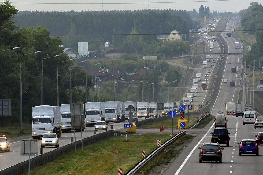 A Russian convoy of trucks carrying humanitarian aid for Ukraine, behind a police escort, drives along a road in the city of Voronezh on Aug 12, 2014.&nbsp;A convoy of nearly 300 trucks carrying what Russia says is humanitarian aid for victims of fig