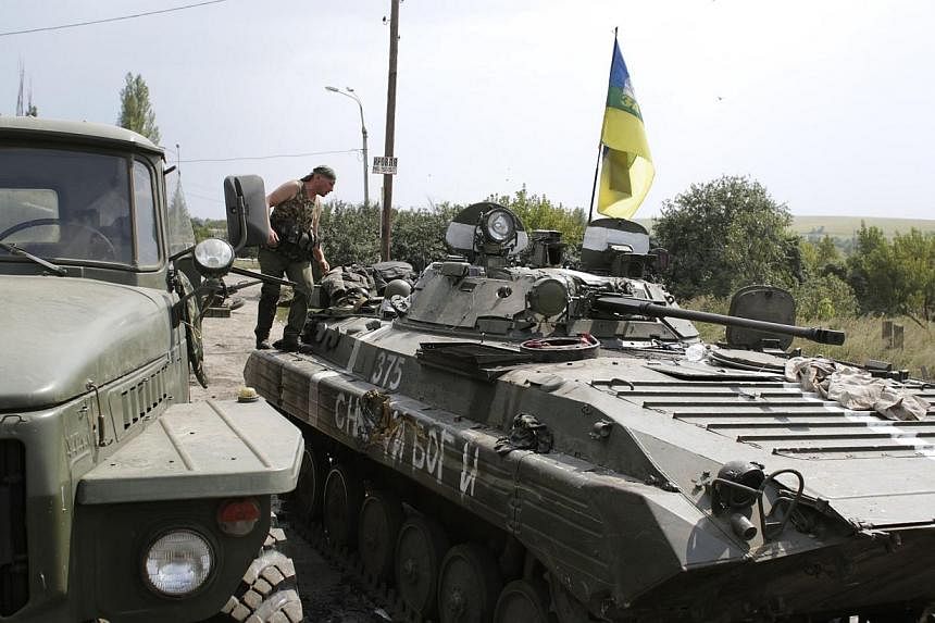 A Ukrainian soldier preparing to refuel his armoured personnel carrier near the eastern Ukrainian city of Donetsk on Monday. Tougher sanctions won't change Russia's approach to Ukraine because Mr Putin is determined that it will eventually become the