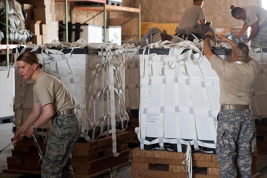 In this Aug 11, 2014 US Air Force handout photo, service member volunteers push a completed pallet of food and water to prepare it for loading onto aircraft at a location in Southwest Asia.&nbsp;The Obama administration has sent about 130 additional 