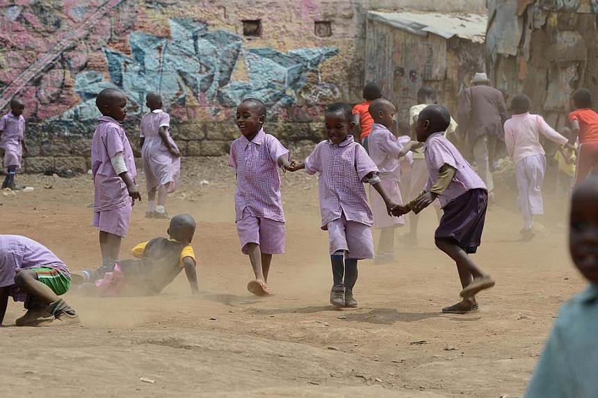 Schoolchildren play on May 28, 2014 in a dusty field in Mathare, one of the poorest slums in Nairobi, Kenya. UNICEF, the UN children's agency, says that&nbsp;within 35 years, based on current trends, 25 in 100 people will be African and&nbsp;40 per c