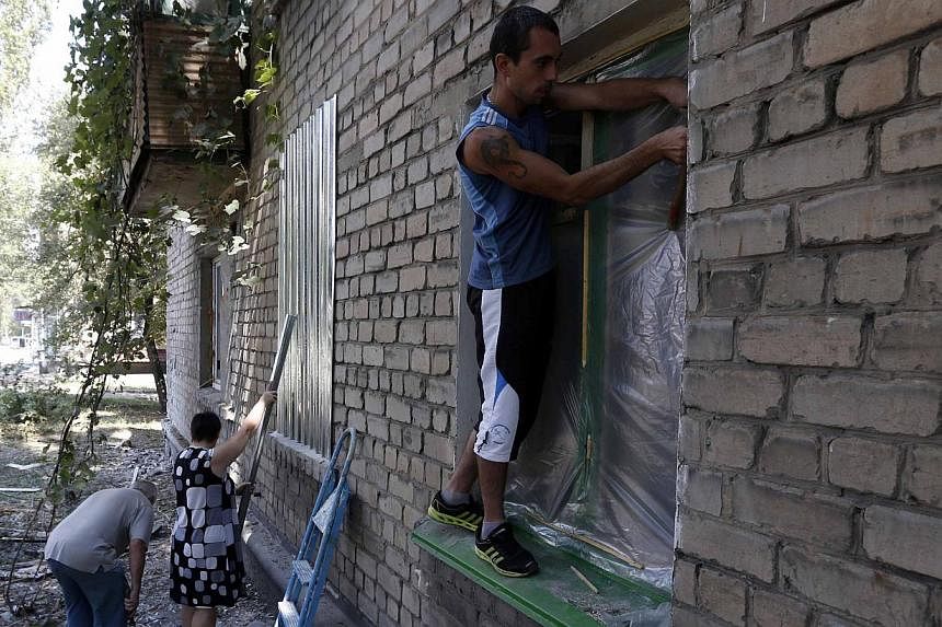 Local residents protect windows with metal shields and plastic in Donetsk August 9, 2014. More than 1,100 people have been killed in the fighting in Ukraine since mid-April, according to the United Nations, in a civil conflict that has dragged ties b