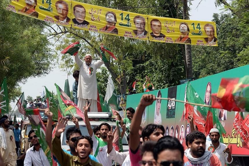 Supporters of cricketer-turned-politician Imran Khan gather outside the residence of Imran before the start of their protest march against government in Lahore on Aug 14, 2014.&nbsp;Thousands of protesters began to march on the Pakistani capital from