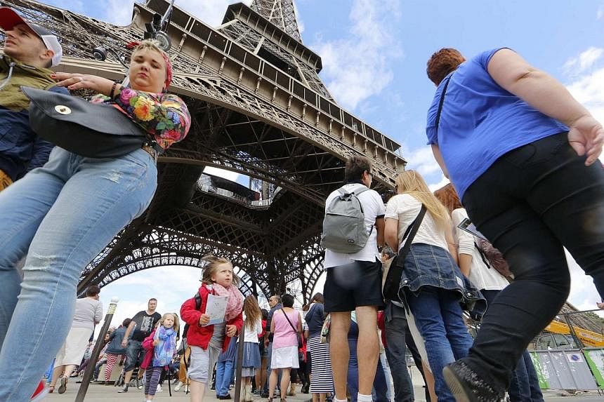 Tourists walk near the Eiffel Tower in Paris on Aug 12, 2014.&nbsp;Spending on tax free shopping at leading destinations dropped for the first time since 2009 in the second quarter, with spending by Russians down sharply due to the fall in the rouble
